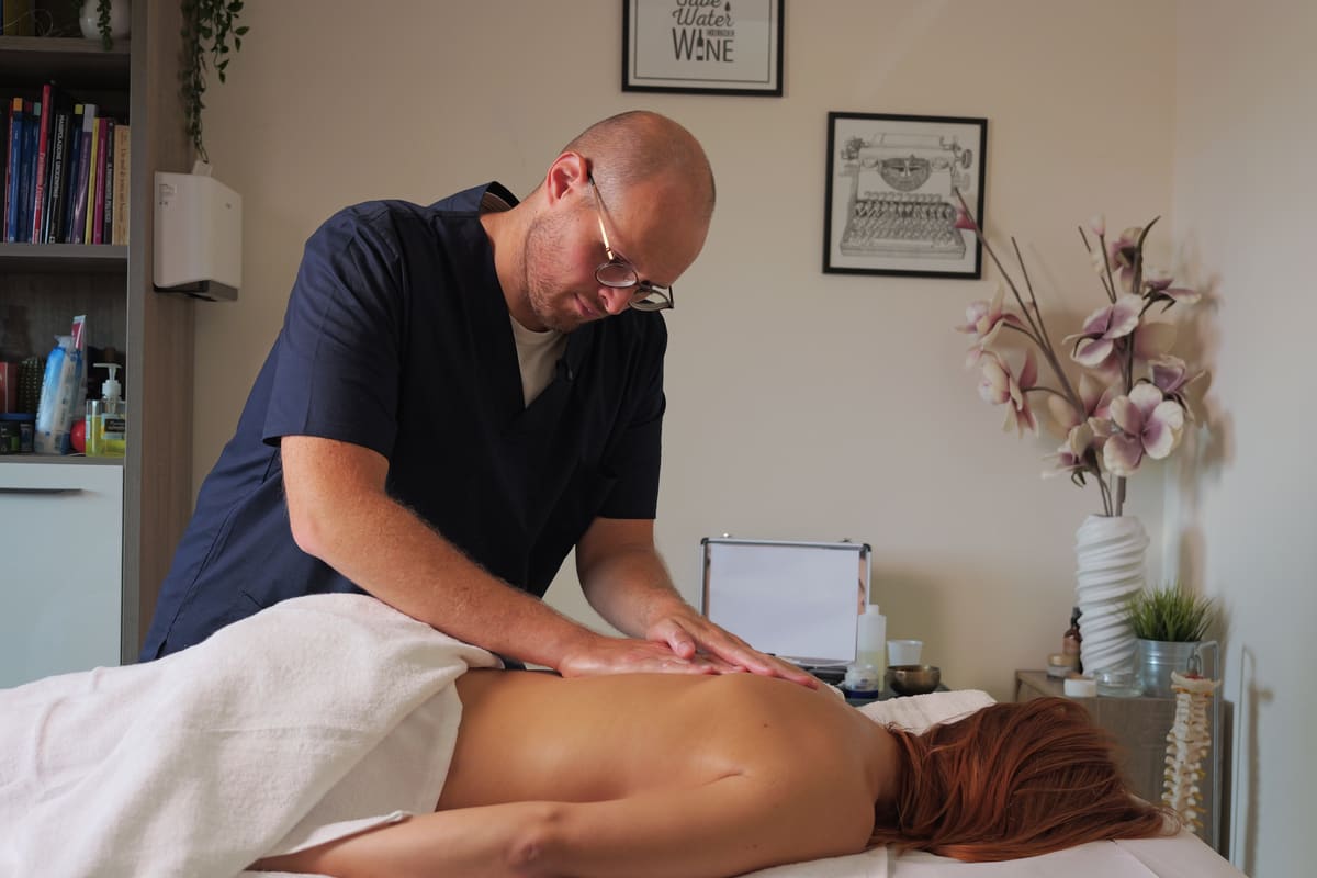 Federico al lavoro nello studio mentre massaggia la schiena di una persona distesa sul lettino